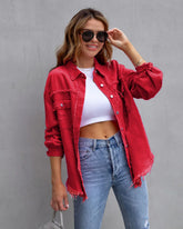 Woman in casual streetwear with red distressed oversized denim jacket, white crop top, blue jeans