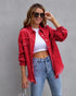 Woman in casual streetwear with red distressed oversized denim jacket, white crop top, blue jeans