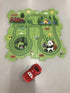 Green cartoon forest puzzle mat with animal illustrations and a red toy car on floor