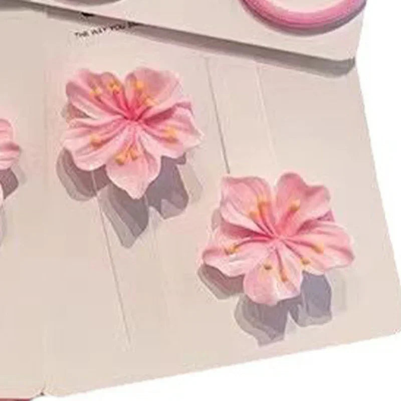 3D pink cherry blossom flower embellishments on white paper background