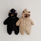 Two hooded baby jumpsuits, one black with cat ears and one beige with bear ears, padded, relaxed fit.