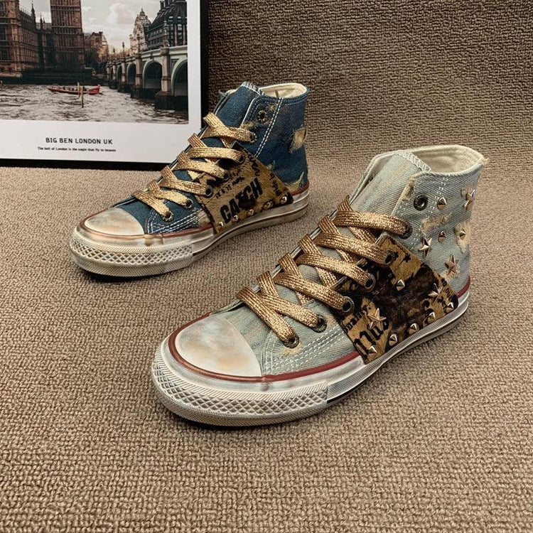 High-top denim sneakers with metallic gold laces, studded accents, and distressed detailing