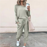Woman in light sage green casual lounge set with jogger pants, long sleeves, relaxed fit, street style.