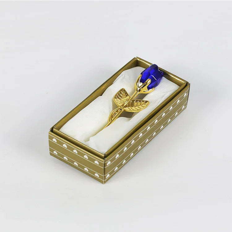 Gold metal rose with blue crystal flower bud in a polka dot gift box