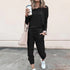 Woman wearing black casual jogger set with long sleeves, tapered pants, and white sneakers