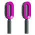 Two modern pink and black hairbrushes with oval heads and ergonomic handles