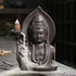 Matte ceramic statue incense burner with flowing smoke and detailed robe design, seen on wooden surface.