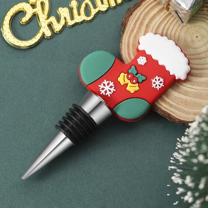 Christmas-themed bottle stopper with red and green silicone stocking design, snowflakes, and metallic tip