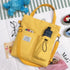 Yellow canvas shoulder bag with front pockets, casual streetwear style, relaxed fit.