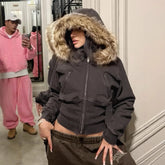 Woman in a fitted black hoodie with faux fur trim and brown sweatpants, streetwear style.