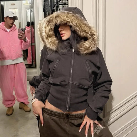 Woman in a fitted black hoodie with faux fur trim and brown sweatpants, streetwear style.