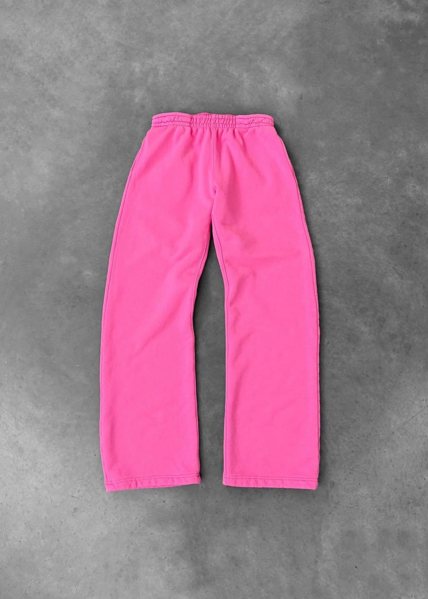 Bright pink fleece sweatpants with elastic waistband, relaxed fit, laid flat on gray background