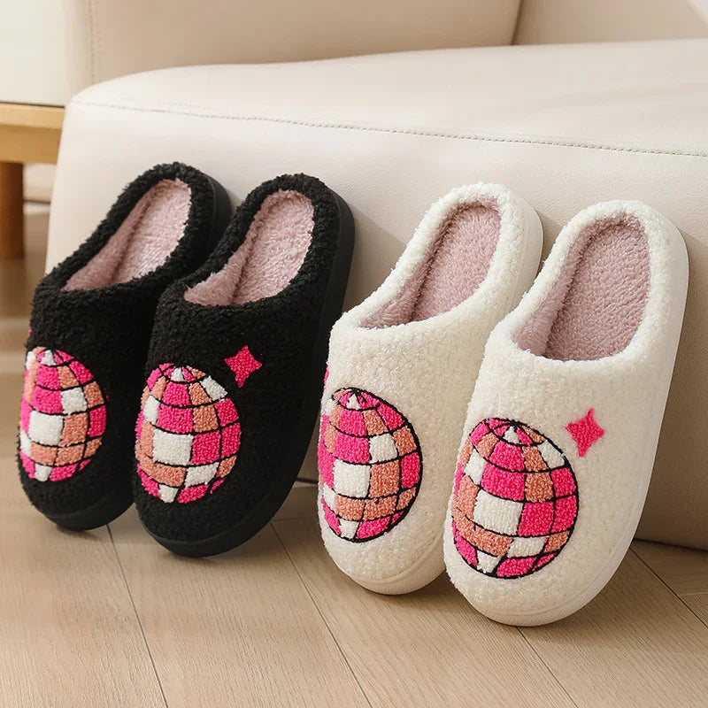 Cozy slip-on slippers in black and white with pink disco ball embroidery, plush fleece material.