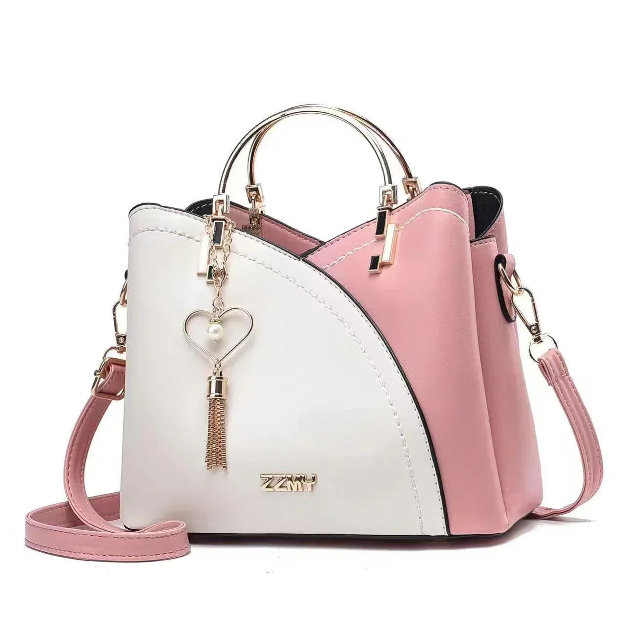 Chic pink and white faux leather handbag with gold handles, heart charm, and crossbody strap.