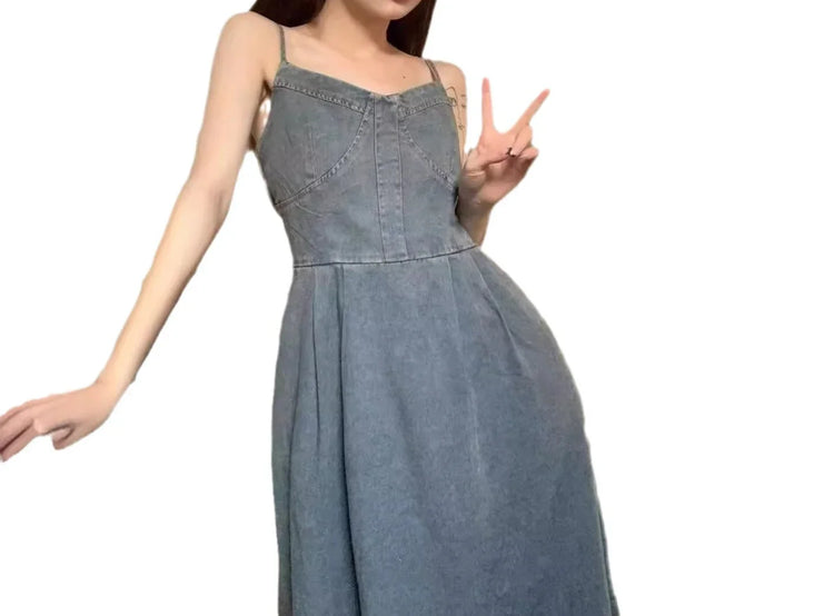 Woman wearing a sleeveless denim dress with spaghetti straps and relaxed fit