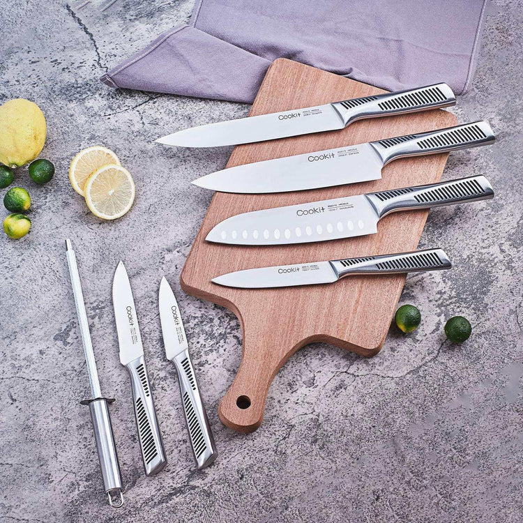 Set of stainless steel kitchen knives with textured handles on wooden cutting board, modern countertop.