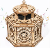 Intricate wooden music box with carved details and decorative wheels, vintage style.