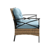 Modern lounge chair with light blue cushions, rattan wicker base, and black metal frame