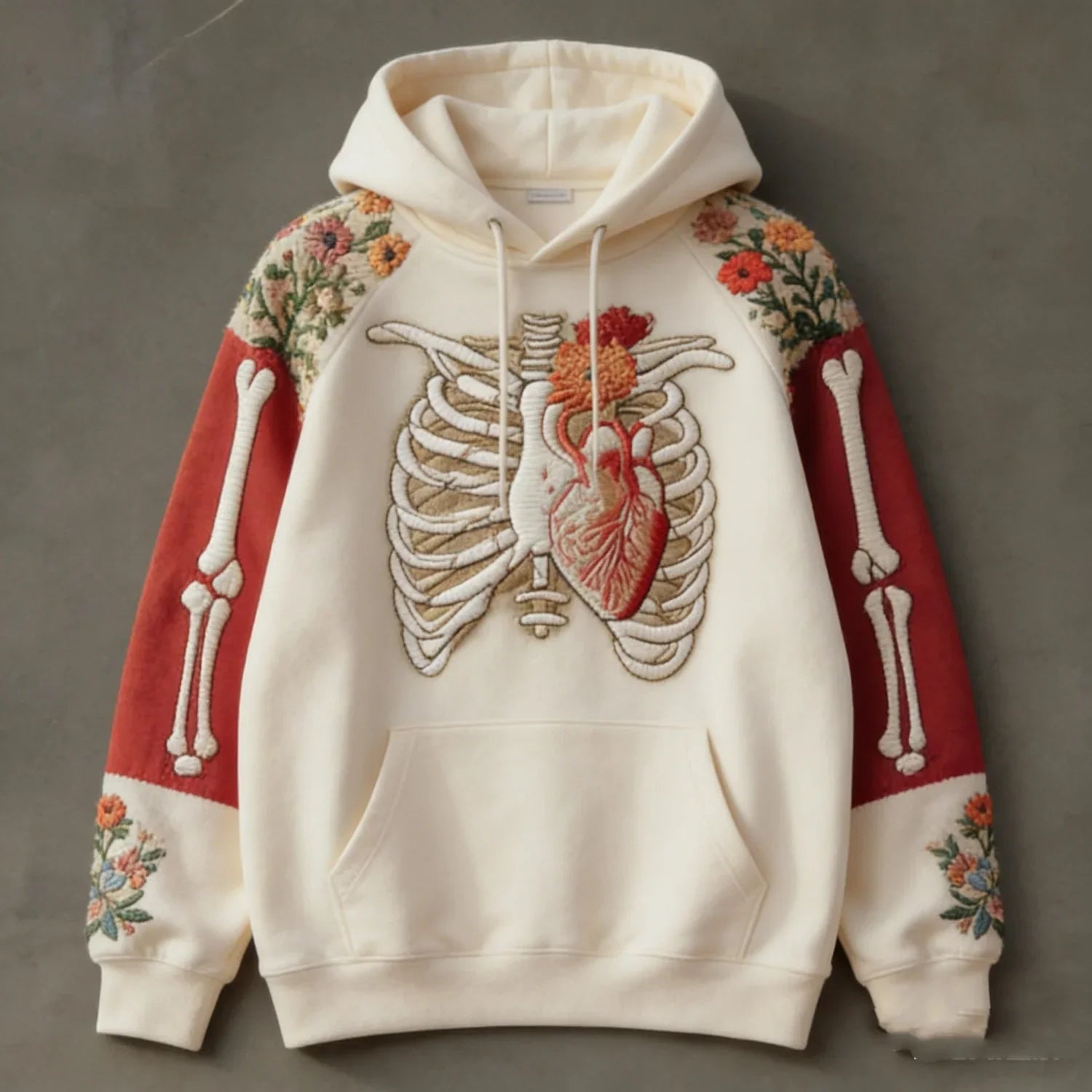 Cream hoodie with ribcage and heart embroidery, red sleeves with skeleton and floral designs, relaxed fit.