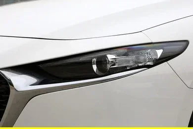Close-up of a white car's sleek LED headlight with chrome trim, modern automotive design