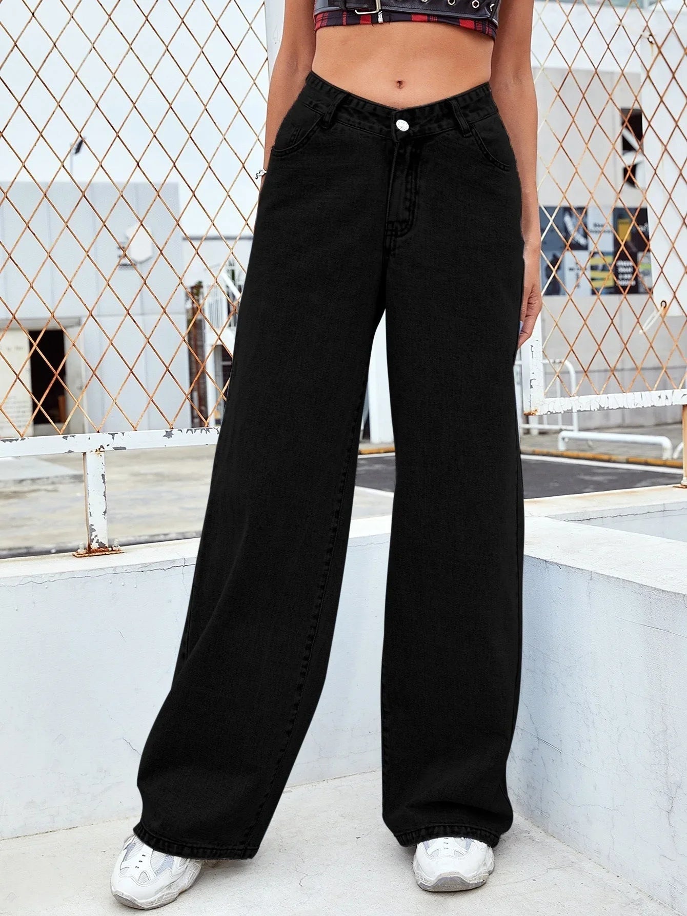 Woman wearing high-waisted black wide-leg jeans, relaxed fit streetwear style