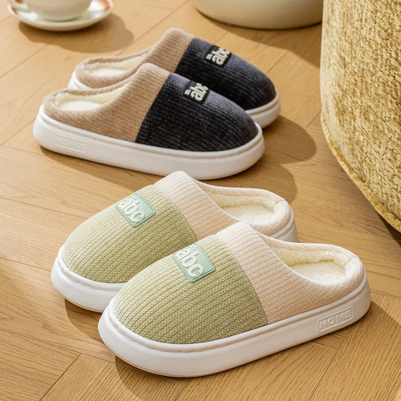 Cozy slip-on house slippers in green and beige with soft fleece lining and textured fabric.