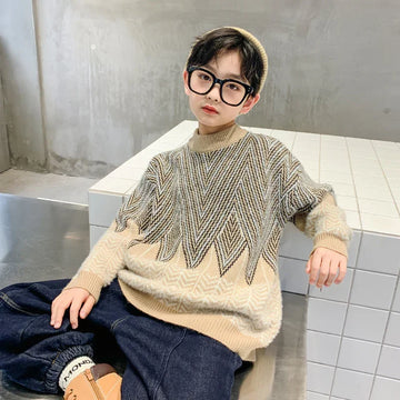 Child in oversized beige and gray patterned knit sweater with relaxed fit, dark jeans, and boots
