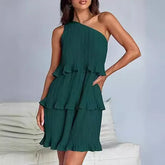 Woman wearing a green pleated one-shoulder dress with ruffle layers, relaxed fit