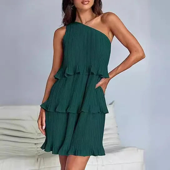 Woman wearing a green pleated one-shoulder dress with ruffle layers, relaxed fit