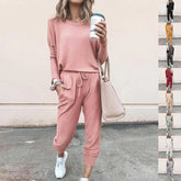 Woman wearing a relaxed-fit pink lounge set with long sleeves and jogger pants, soft knit material