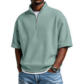 Light green waffle knit short sleeve pullover with zip collar, relaxed fit, paired with jeans