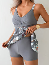 Woman wearing gray floral activewear set with fitted shorts and a wrap top, soft stretch fabric