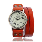 Vintage-style watch with large numerals, brown leather wrap strap, and metal rivet accents.