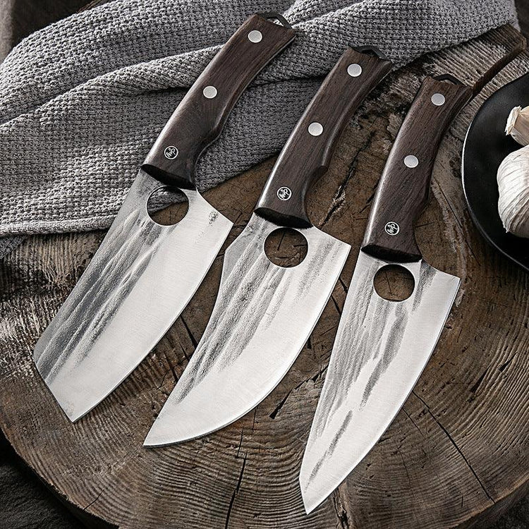 Three stainless steel chef knives with dark wood handles and large blade holes, displayed on wooden surface