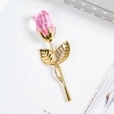Gold metal rose brooch with pink crystal flower, elegant accessory on white background