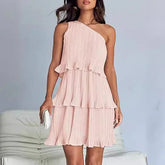 Woman wearing a light pink one-shoulder pleated chiffon dress with tiered ruffles