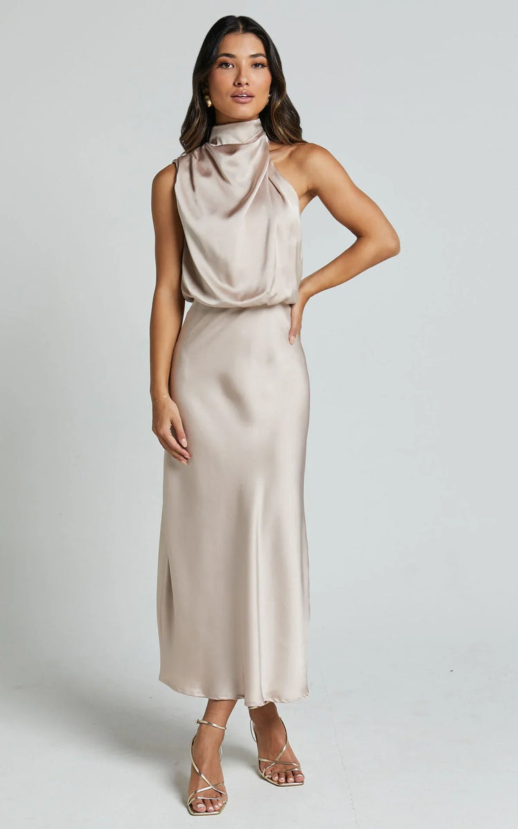 Woman wearing a sleeveless champagne satin midi dress with draped high neckline and slim fit
