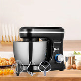 Black and silver stand mixer with stainless steel bowl and three metal attachments on a kitchen counter