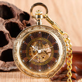 Gold vintage pocket watch with intricate detailing, black dial, Roman numerals, and chain