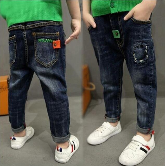 Children's relaxed fit dark wash denim jeans with colorful patch accents and cuffed hems