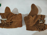 Pair of brown suede boots with fringe, slouchy fit, and decorative side details