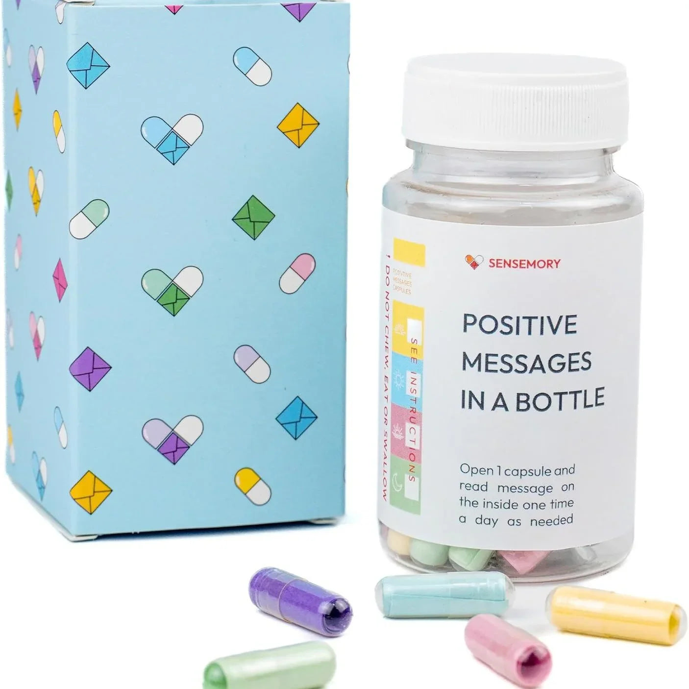 Bottle of colorful capsules with messages, next to a pastel blue box with heart and pill prints.