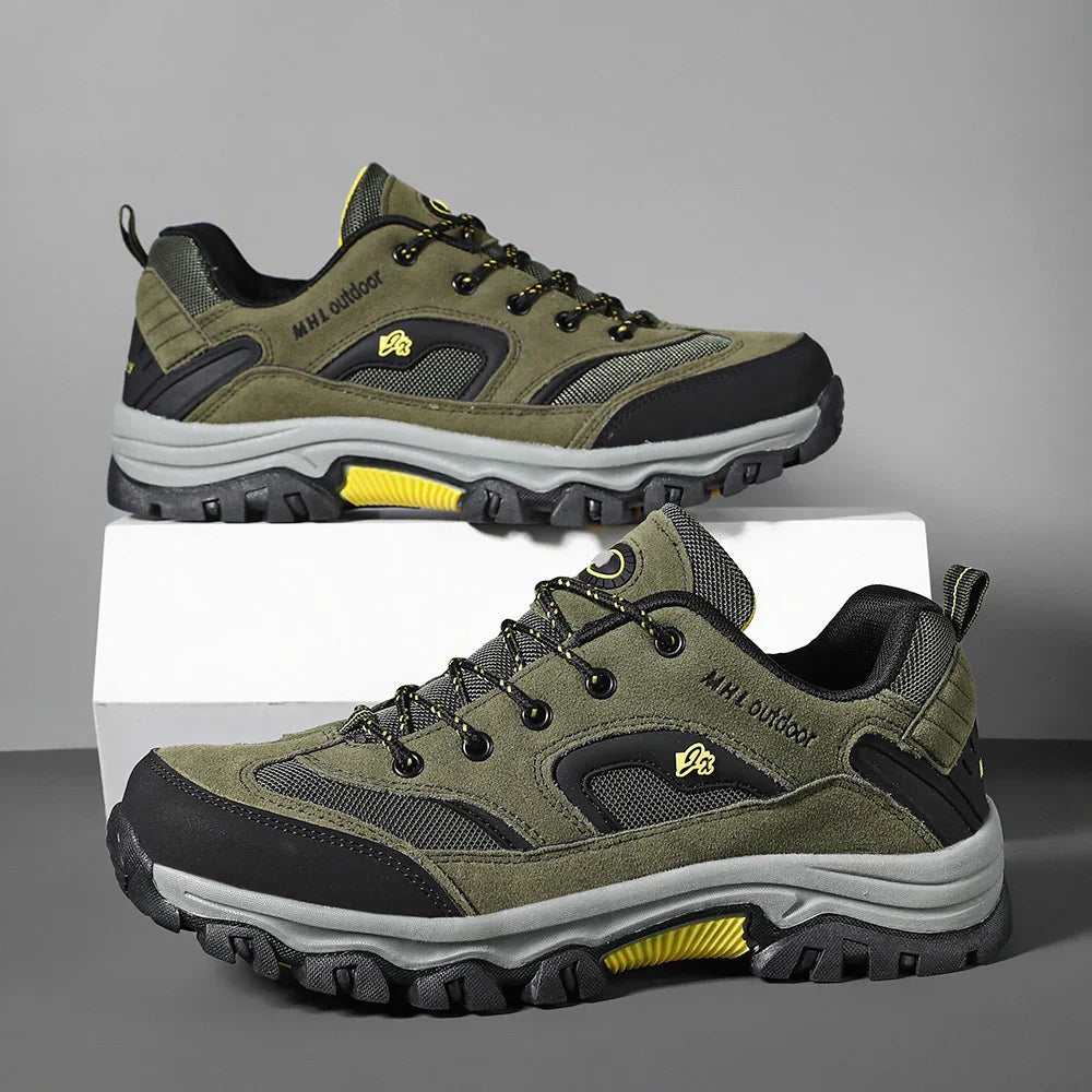 Olive green and black rugged outdoor sneakers with yellow accents, mesh panels, and thick soles