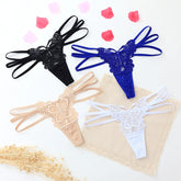 Four lace butterfly thong panties in black, blue, beige, and white with strappy sides, flat lay display.