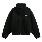 Black oversized streetwear jacket with high collar, snap buttons, and front flap pockets