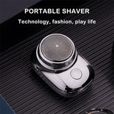 Sleek silver portable electric shaver with circular foil head on ribbed black surface