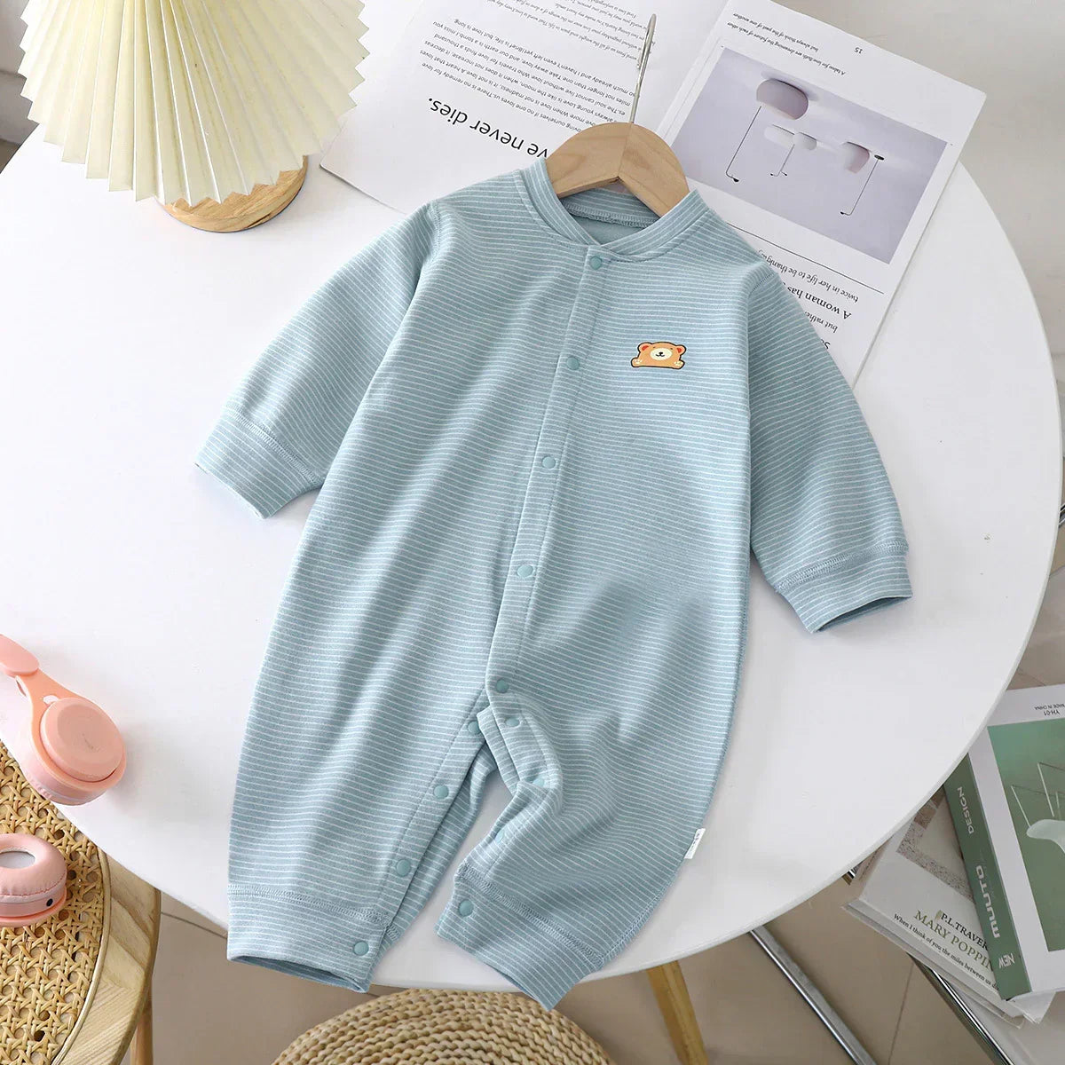 Light blue striped baby romper with snap buttons and long sleeves, soft cotton material, relaxed fit