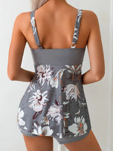 Back view of woman wearing gray floral tankini top with adjustable straps and relaxed fit