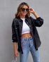 Woman wearing black distressed denim jacket, white crop top, and light wash high-waisted jeans
