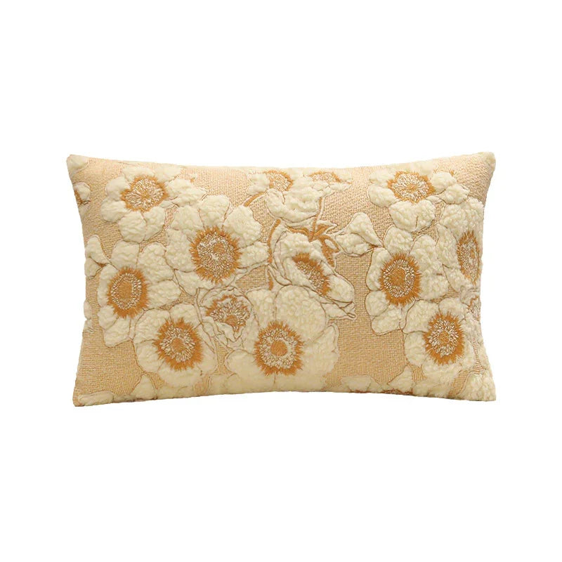 Rectangular beige cushion with embroidered cream and yellow floral pattern, textured fabric